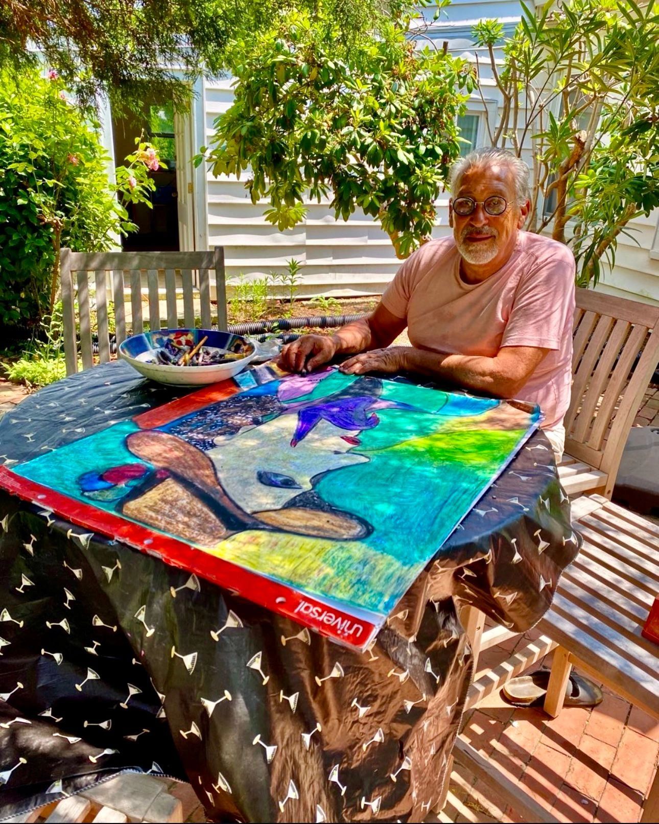 Agustin Ochoa painting at an outdoor table